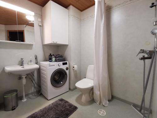 a bathroom with a washing machine and a sink at Rovaniemi Cityhome Sunnarborg in Rovaniemi