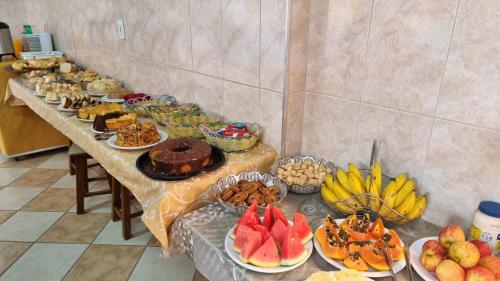 a long table filled with different types of food at Hotel Pousada Recanto da Madá in Aparecida