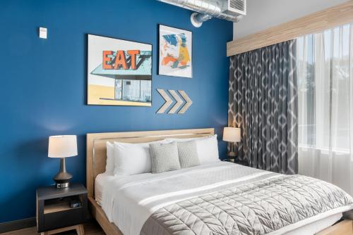 a bedroom with blue walls and a bed with white pillows at Cannery Lofts Niagara in Niagara Falls