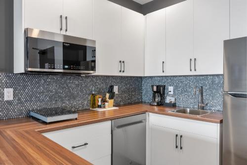 a kitchen with white cabinets and a wooden counter top at Cannery Lofts Niagara in Niagara Falls