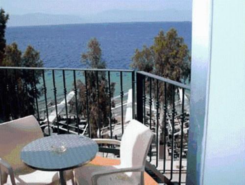 a balcony with a table and chairs and the ocean at Thalassa in Loutra Edipsou