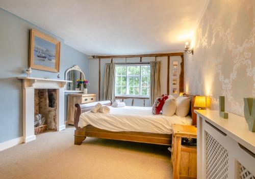 a bedroom with a large bed and a fireplace at The Manor House in Bramfield