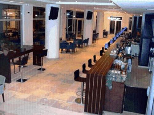 a large room with a bar with chairs and tables at Thalassa in Loutra Edipsou
