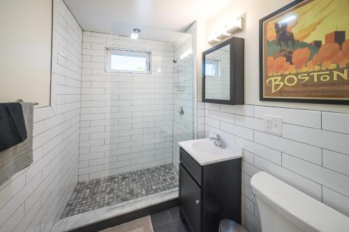 a white bathroom with a sink and a toilet at The Boston Rental - Multiple Floorplans in Boston