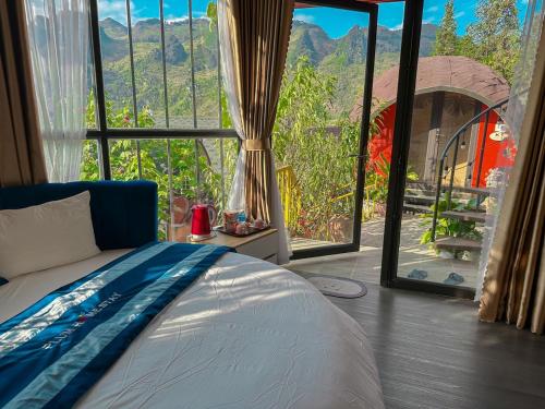 a bedroom with a bed and a large window at Plum Homestay in Dồng Văn