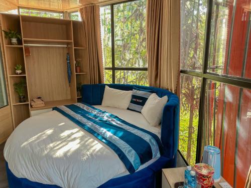a blue bed in a room with a window at Plum Homestay in Dồng Văn