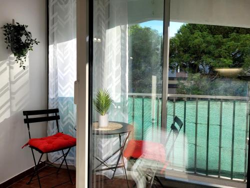 ラ・グランド・モットにあるLes Appartements De Lina By LG Immo - Self Check-In -の窓の前にテーブルと椅子が備わるバルコニー
