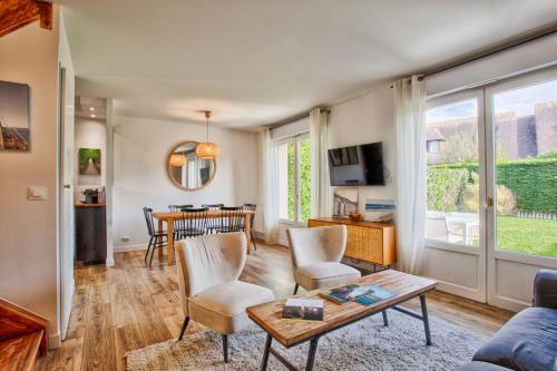 sala de estar con mesa y sillas en Sweet Home - PiscineTennis - Deauville, en Deauville