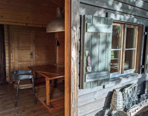 a wooden cabin with a table and a window at Blockhütte 35 km nördlich von Hamburg in Langeln