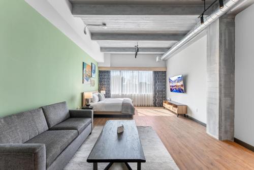 a living room with a couch and a bed at Cannery Lofts Niagara in Niagara Falls