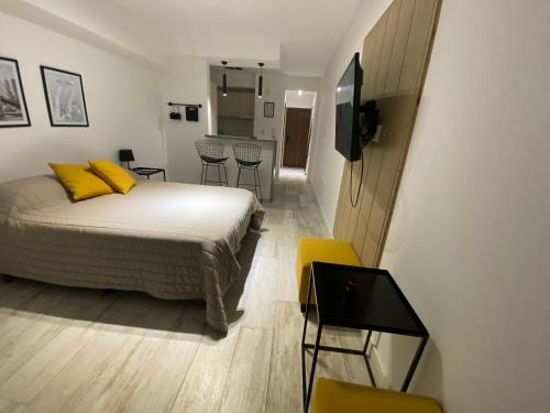 1 dormitorio con 1 cama, mesa y sillas en STUDIO BARRACAS en Buenos Aires