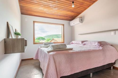 a bedroom with a large bed with a window at Requinte, conforto e privacidade in Pirenópolis