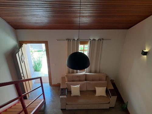 a living room with a couch and a black lamp at Requinte, conforto e privacidade in Pirenópolis