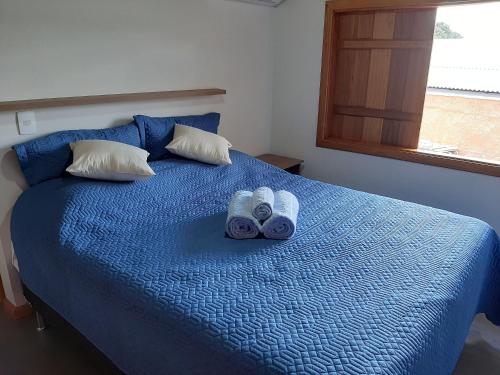 a blue bed with two towels on top of it at Requinte, conforto e privacidade in Pirenópolis