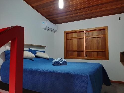 a bedroom with a blue bed and a wooden cabinet at Requinte, conforto e privacidade in Pirenópolis