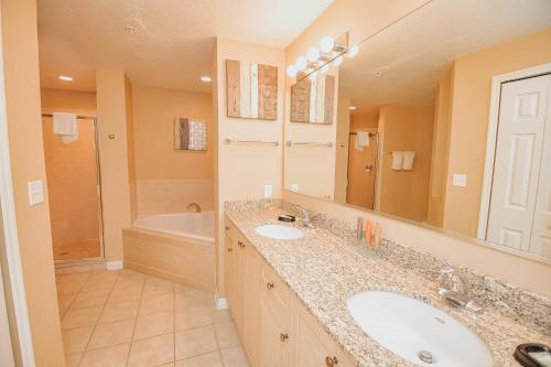 ein Badezimmer mit zwei Waschbecken und einem großen Spiegel in der Unterkunft WorldQuest Orlando Resort in Orlando