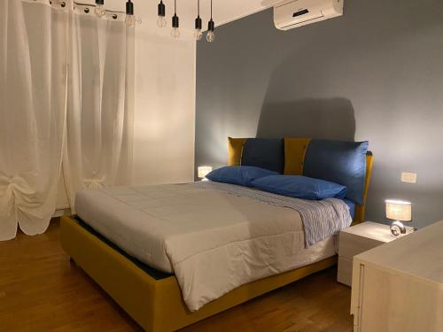 a bedroom with a bed with blue pillows at Il Principio - zona Fiera e Policlinico in Pordenone