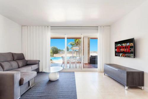 a living room with a couch and a table at Lujoso y Equipado Apartamento en Playa del Arenal in Jávea