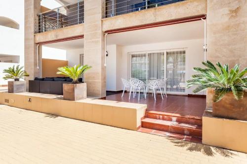 a house with a patio with chairs and plants at Lujoso y Equipado Apartamento en Playa del Arenal in Jávea