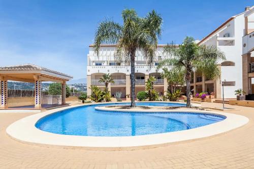 a swimming pool in front of a building at Lujoso y Equipado Apartamento en Playa del Arenal in Jávea