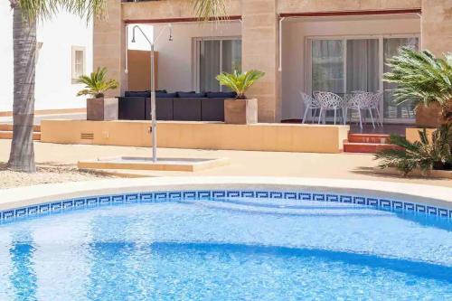 a swimming pool in front of a house at Lujoso y Equipado Apartamento en Playa del Arenal in Jávea