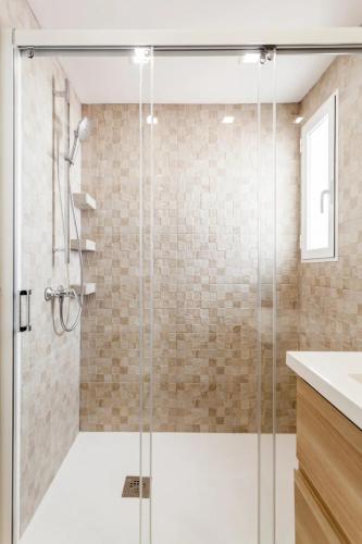 a shower with a glass door in a bathroom at Lujoso y Equipado Apartamento en Playa del Arenal in Jávea