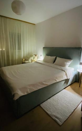 シビウにあるCozy Apartmentのベッドルーム1室(緑のヘッドボード付きの大型ベッド1台付)
