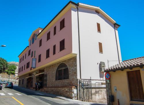 a tall white building on the side of a street at Hotel Meridiana in Arbus