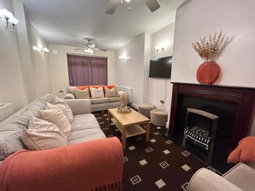 ein Wohnzimmer mit einem Sofa und einem Kamin in der Unterkunft Large House/Contractors/Families in Birmingham