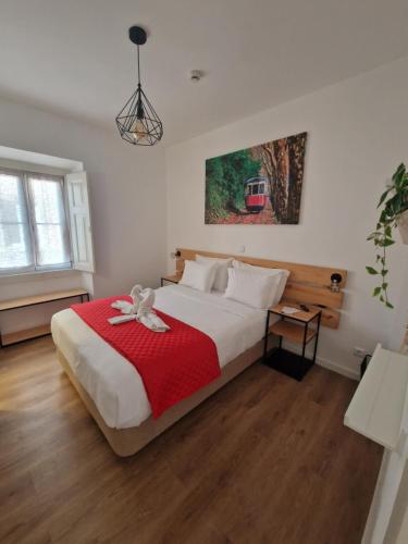 a bedroom with a large bed with a red blanket at Casa do Albuquerque II in Sintra