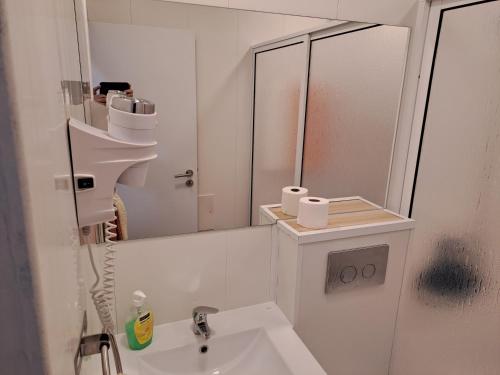 a white bathroom with a sink and a mirror at Residencial Melba in Funchal