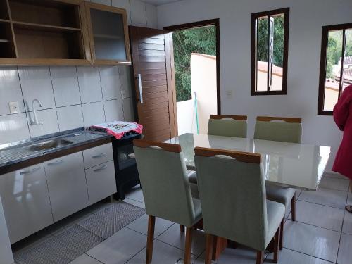 een keuken met een tafel en stoelen in een kamer bij Aluguel temporada- Praia in Governador Celso Ramos