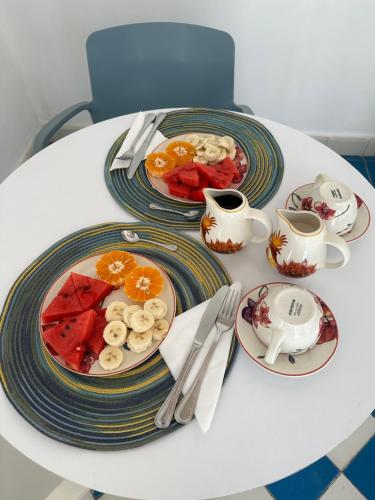 einen weißen Tisch mit Obstteller und Tassen Kaffee in der Unterkunft Placita Vieja Hotel Boutique Spa in Santa Marta