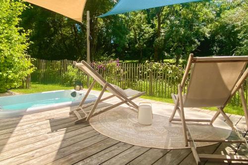 a chair and an umbrella on a deck next to a tub at Chambres avec Jacuzzi privatif - Kassiopée Bed & Spa in Albi