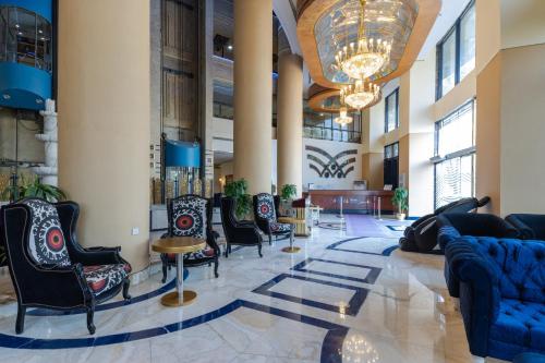 a lobby with chairs and tables and a chandelier at Montana Al Azizia Hotel in Makkah