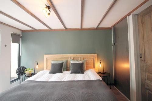 een slaapkamer met een groot bed met 2 kussens bij Bed & Breakfast De Ruige Weide in Oudewater