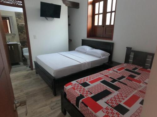 um quarto com duas camas num quarto em HOTEL COLONIAL em Buga