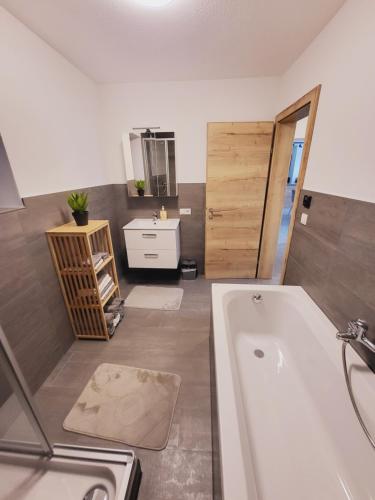 a bathroom with a bath tub and a sink at Bergblick Wohnung Posch in Imst