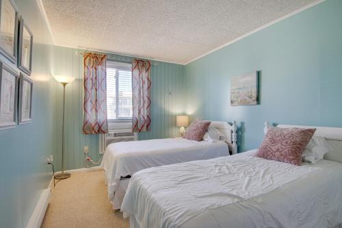 two beds in a room with blue walls at Ocean City Condo - Steps to Beach! in Ocean City