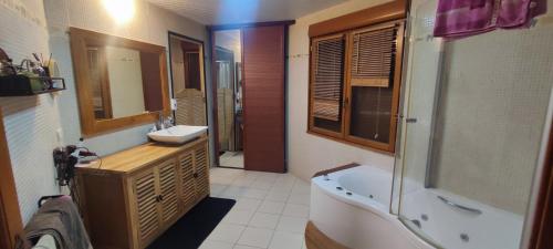 a bathroom with a tub and a sink and a bath tub at Chambre chez l'habitant in Châteaubriant