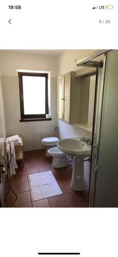 a bathroom with two toilets and a sink and a mirror at Etti's House in Malcesine