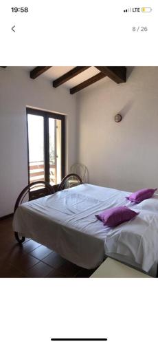 a bedroom with a large bed with purple pillows at Etti's House in Malcesine
