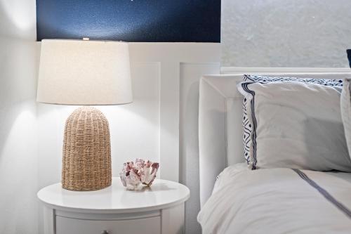 a bedroom with a bed with a table with a lamp at Oceanfront Cocoa Beach Vacation Home Private Beach, Tiki Bar & Family Fun in Cocoa Beach