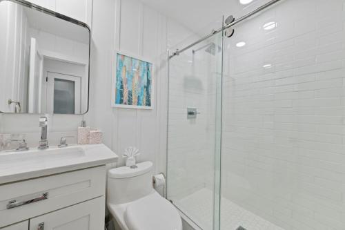 a bathroom with a shower and a toilet and a sink at Oceanfront Cocoa Beach Vacation Home Private Beach, Tiki Bar & Family Fun in Cocoa Beach