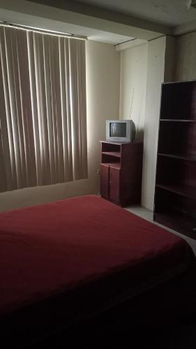 1 dormitorio con 1 cama, TV y ventana en Barlovento1, en Esmeraldas