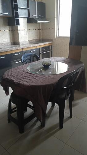 a wooden table in a kitchen with two chairs at Barlovento1 in Esmeraldas