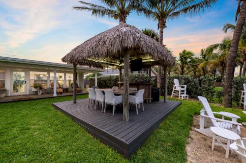 a deck with a gazebo with a table and chairs at Oceanfront Cocoa Beach Vacation Home Private Beach, Tiki Bar & Family Fun in Cocoa Beach