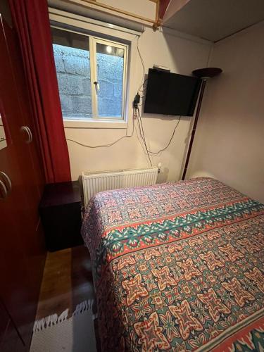 ein kleines Schlafzimmer mit einem Bett und einem Fenster in der Unterkunft Cabañas LUPA in Punta Arenas
