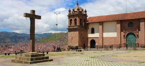 a church with a cross in front of a building at Illa B&B in Cusco