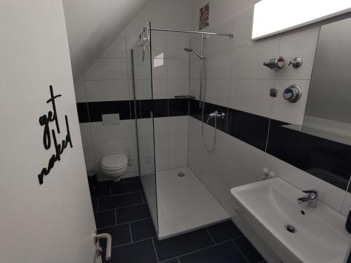 a bathroom with a shower and a sink and a toilet at Loft 29 in Ulm